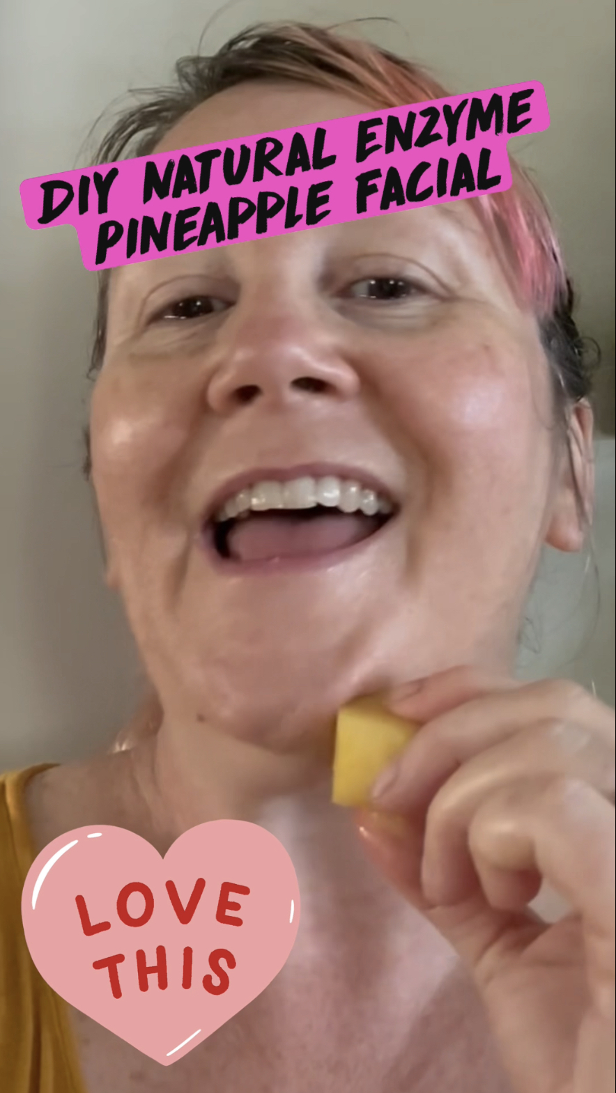pink haired woman using fresh opineapple as a facial enzyme scrub