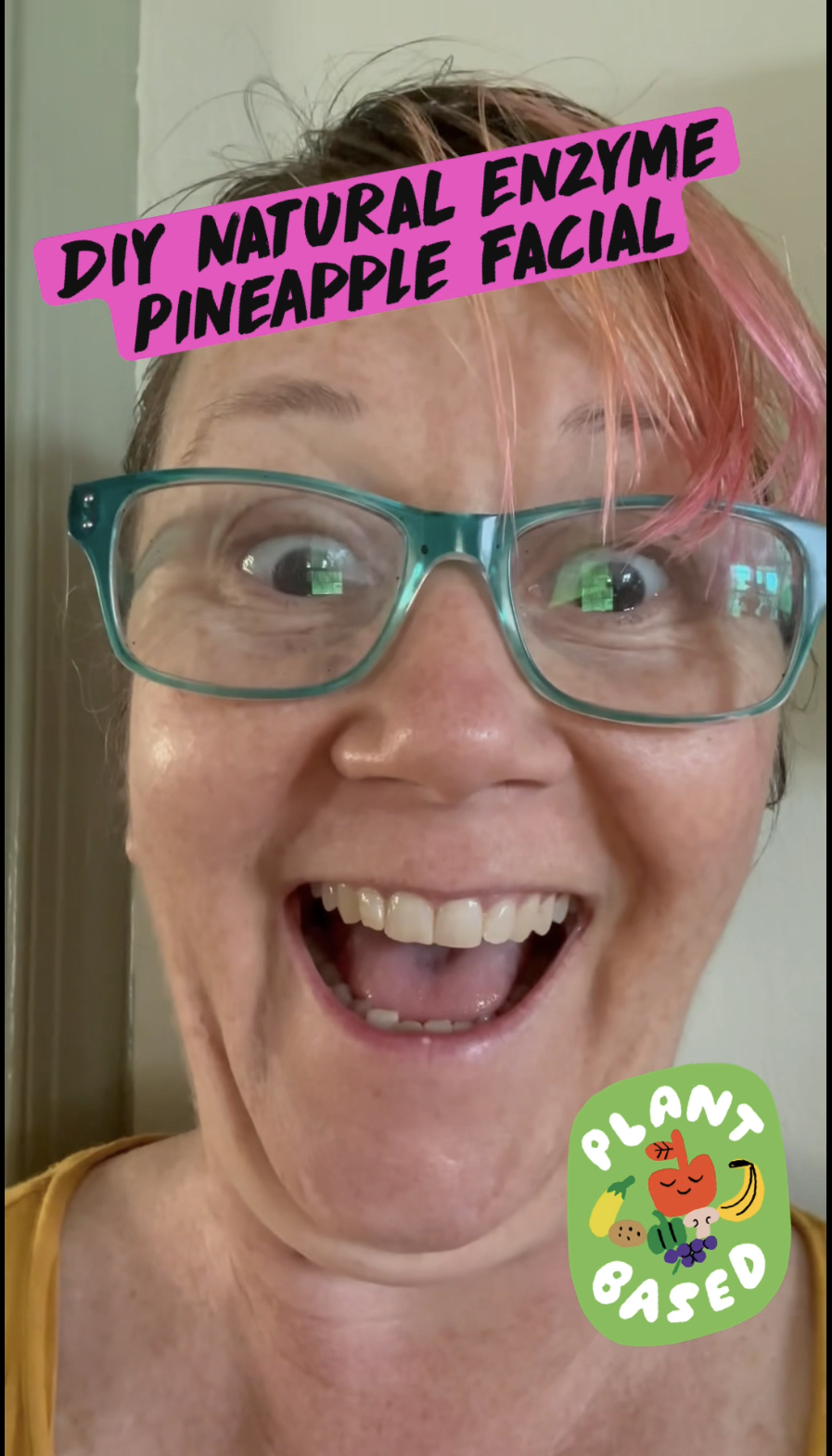 pink haired woman using fresh pineapple as a facial enzyme scrub