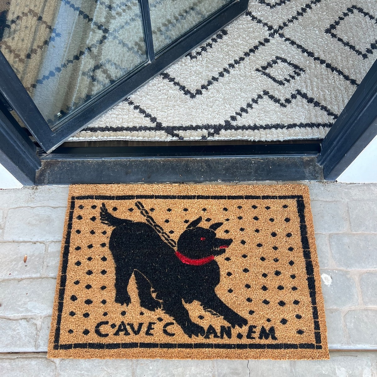 A coir doormat under a covered porch, the placement that extends its lifespan.