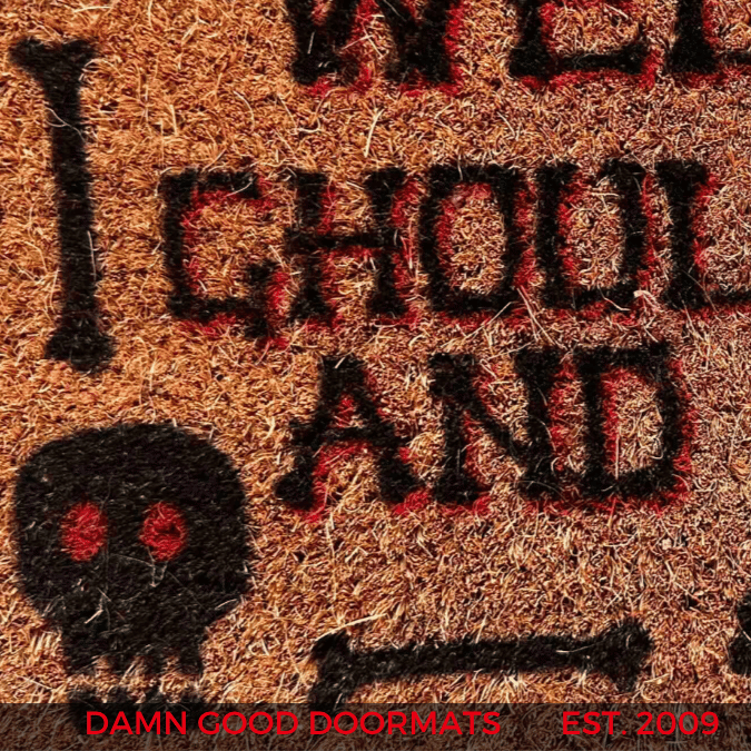 Close-up of blackletter gothic lettering on a coir doormat