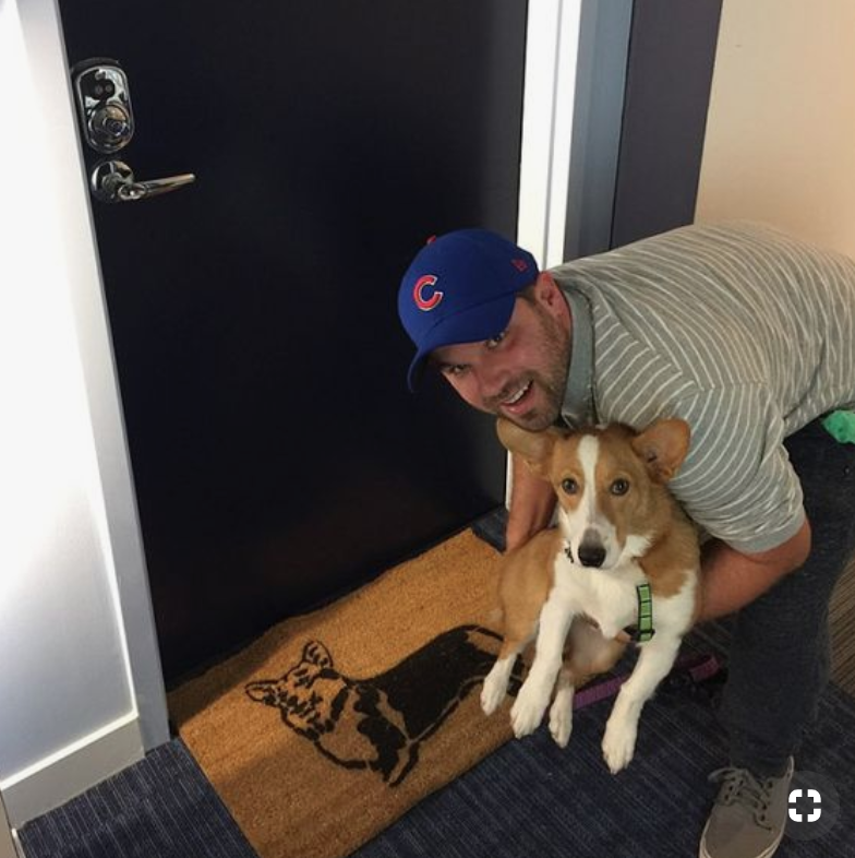 customer picture of a durable coir doormat at an apartment doorstep with a corgi dog.