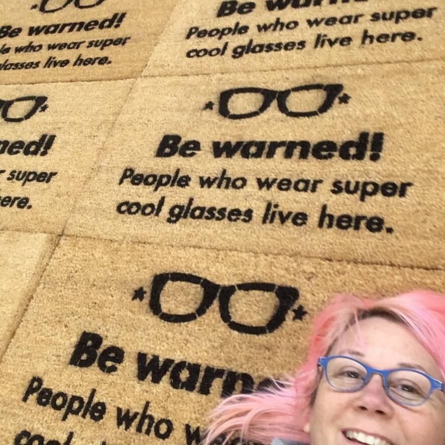 "A dozen custom doormats packed and ready to ship to remote employees across the US"