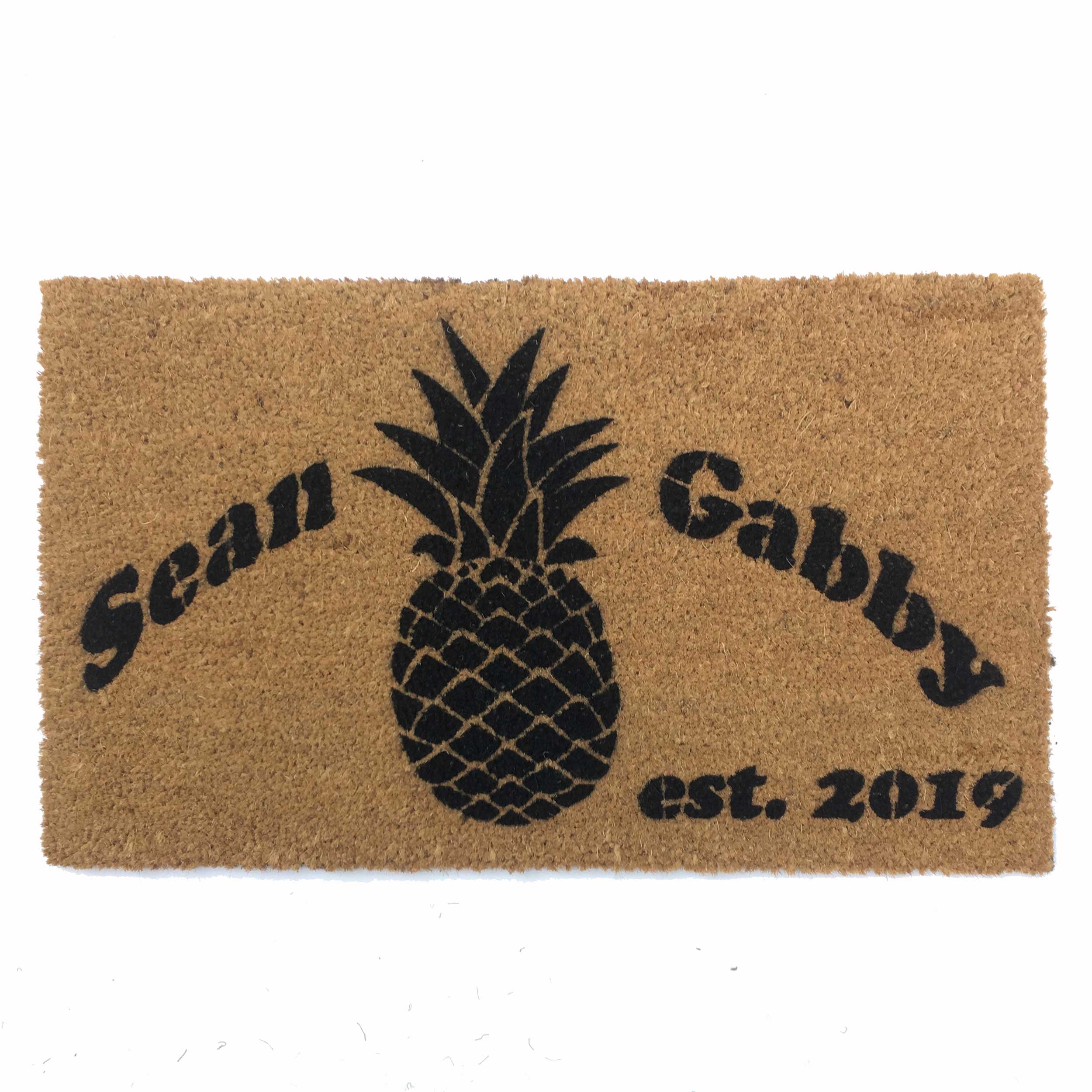 custom name and date on a coir doormat featuring a pinapple graphic from damn good doormats