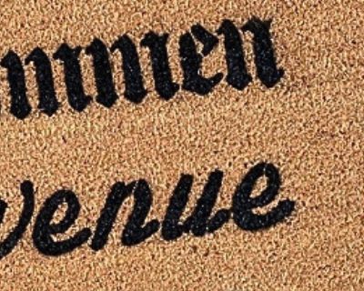Close-up of coarse coir texture and bold lettering on an oversized doormat.