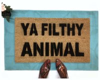 Ya Filthy Animal Home Alone doormat on top of a blue layering rug