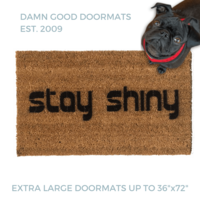 Stay Shiny Firefly themed doormat pictured with a black pug in a red harness looking up