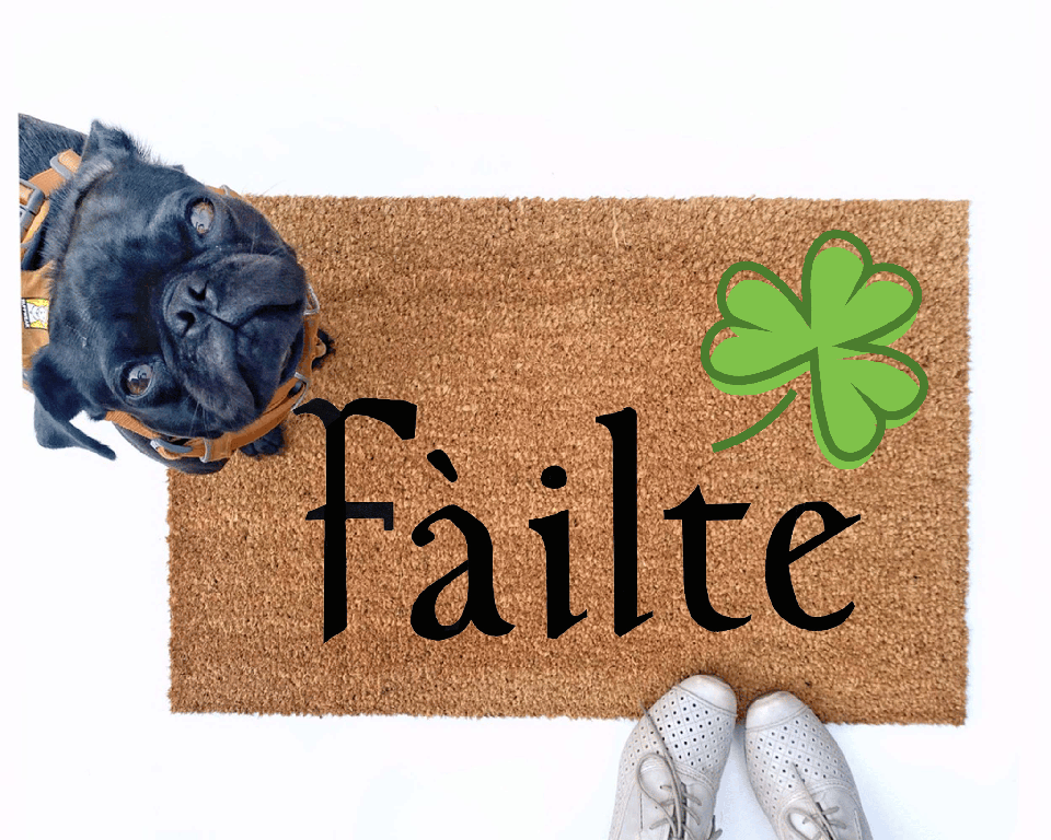 Failte shamrock St Patrick's day coir doormat with a little black pug