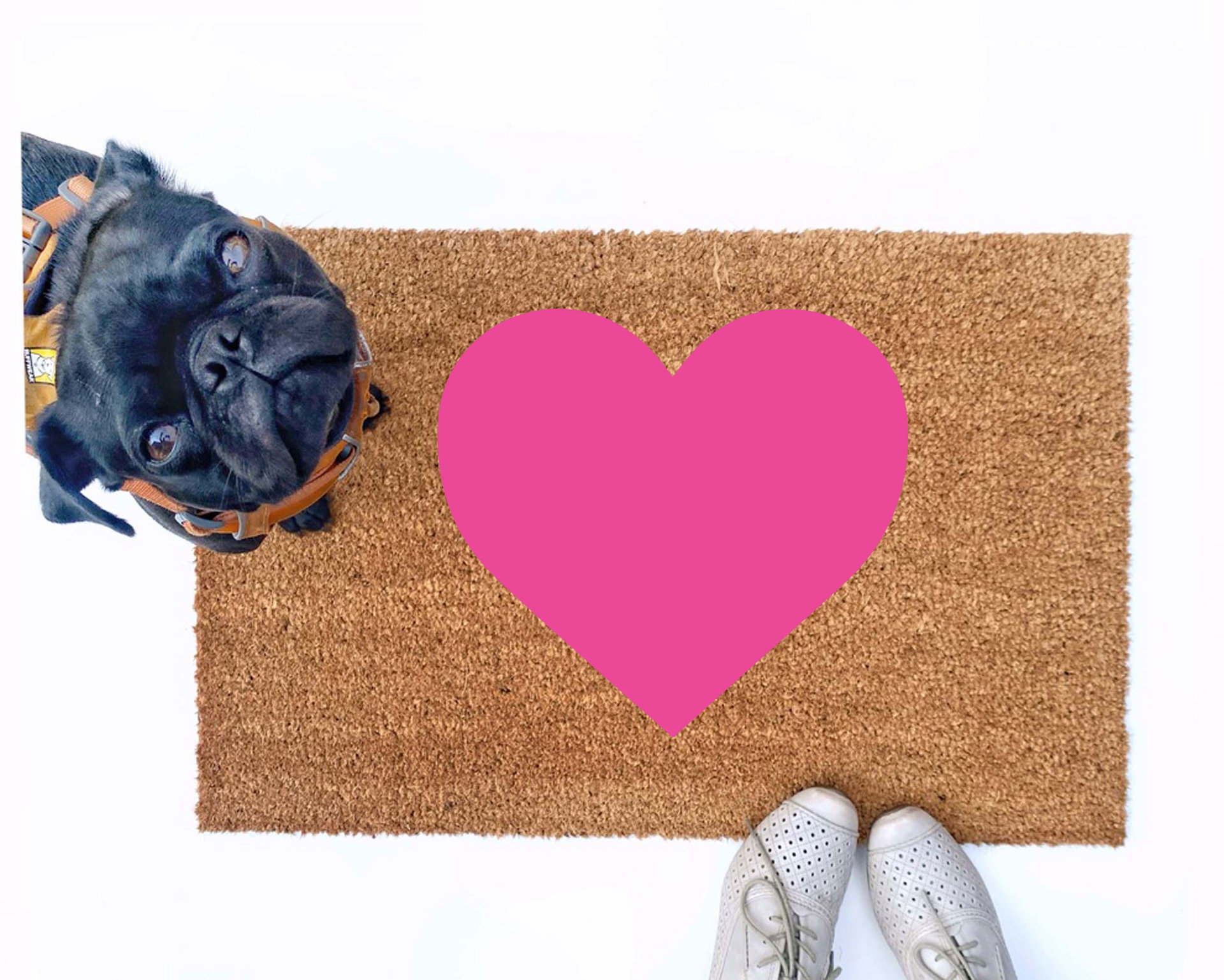 cute pink heart Valentine's Day doormat shown with a little black pug