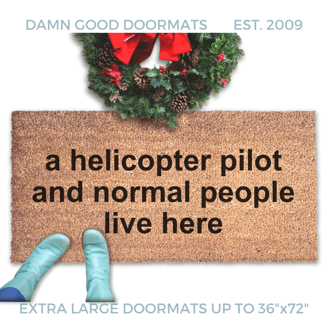 large door mat reading "a helicopter pilot and normal people live here" with a christmas wreath and woman in smurf blue boots
