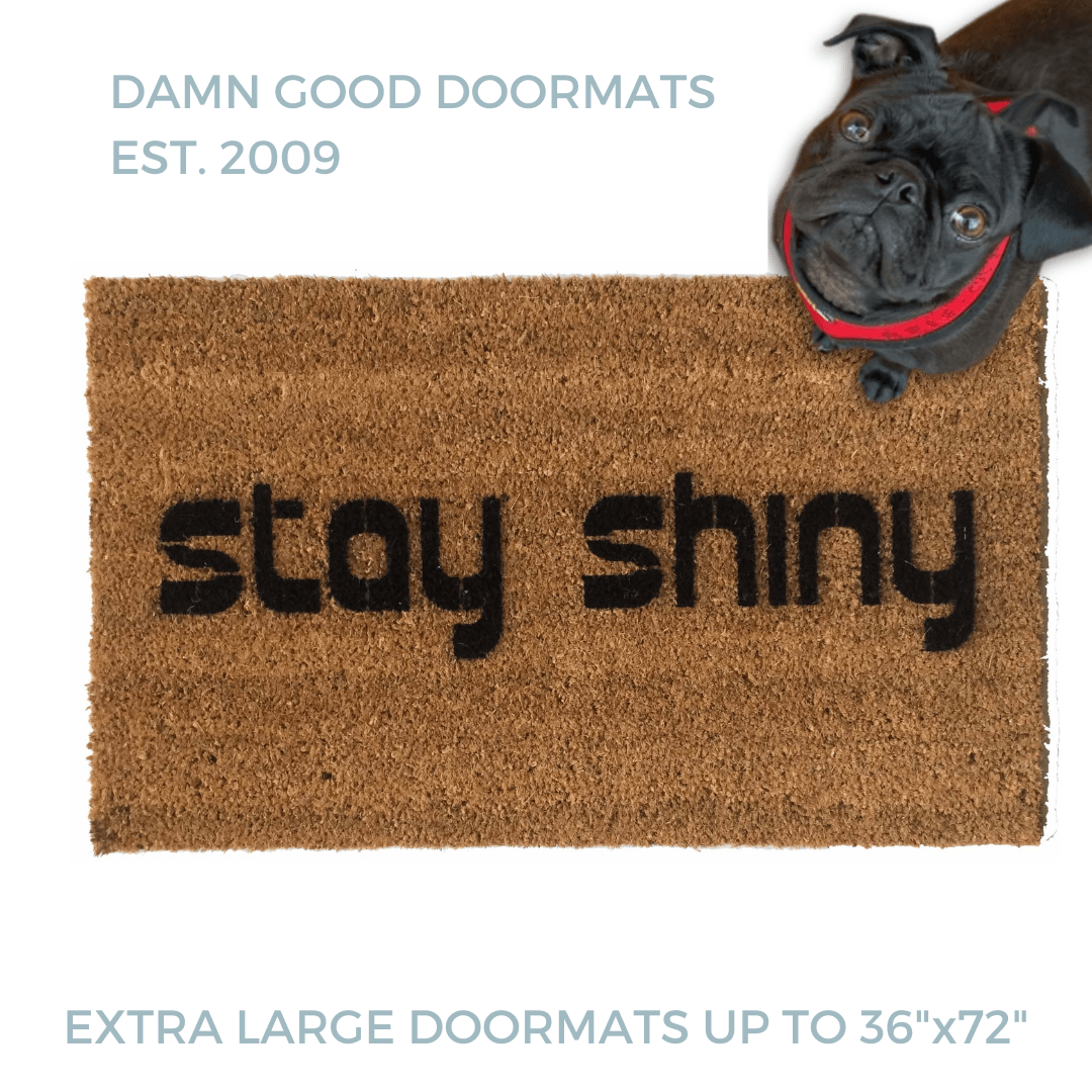 Stay Shiny Firefly themed doormat pictured with a black pug in a red harness looking up