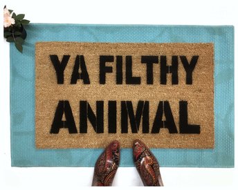 Ya Filthy Animal Home Alone doormat on top of a blue layering rug